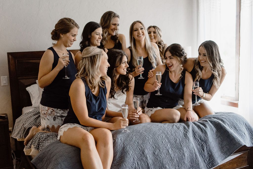 Bride and Bridesmaids Toasting on Bed in Pajamas