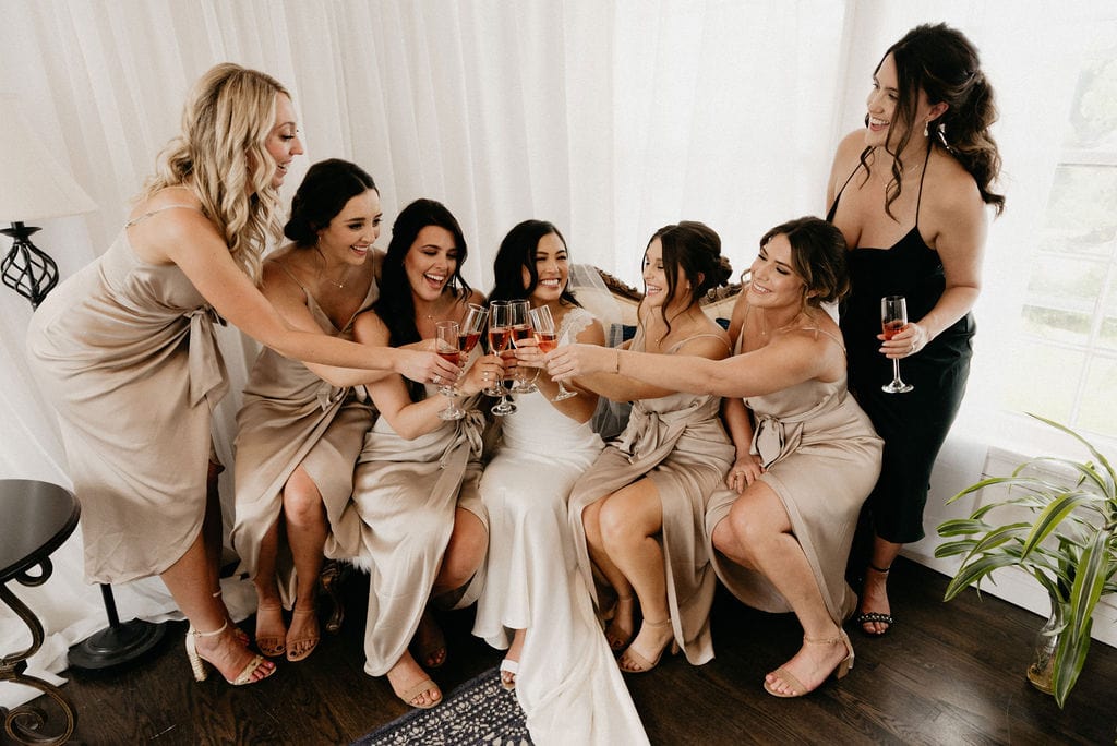 Bride and her bridesmaids cheers to the day