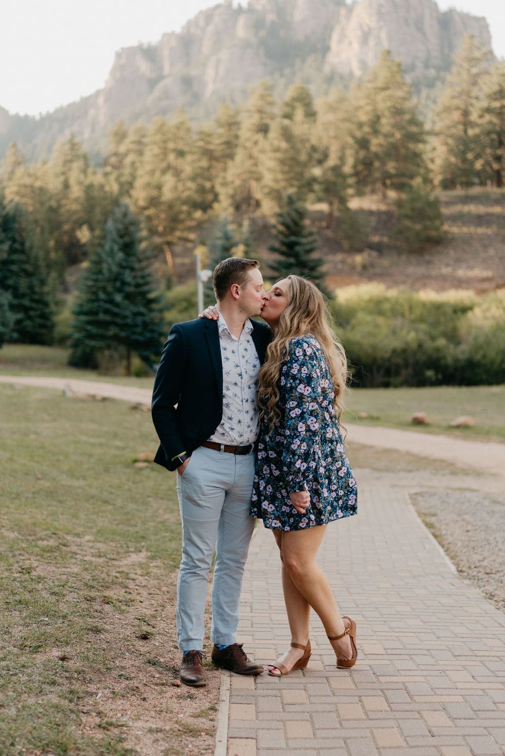 Wedding guests kiss in front of mountain at wedding