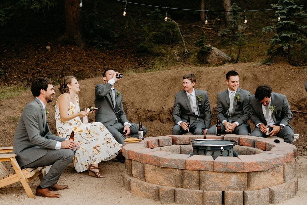 wedding guests hang out around fire pit