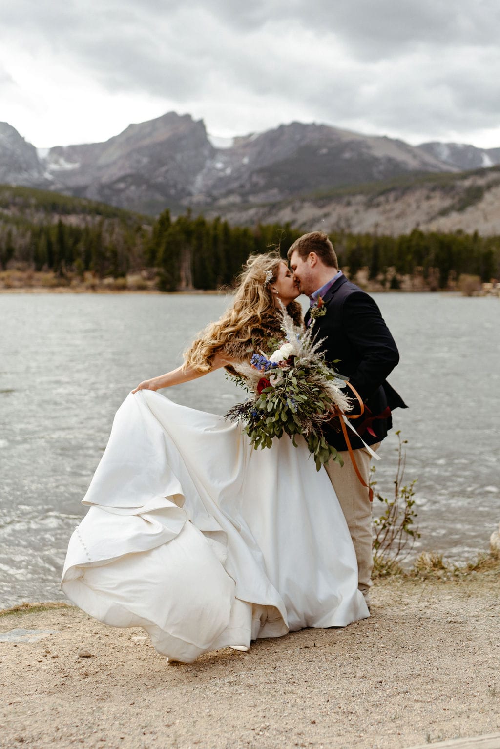 Bride and groom at their windy wedding ceremony at sprague lake in rocky mountain national park