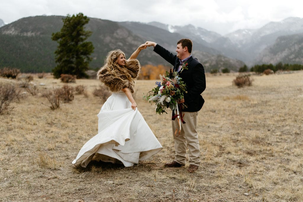 Bride and groom dance amongst mountains in rocky mountain national park