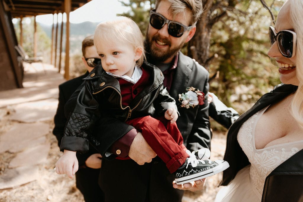 Bride and groom hang out and show off babys custom converse before their estes park elopement