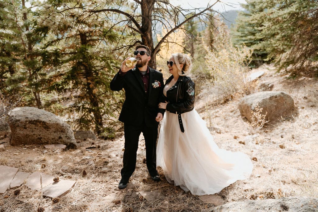 Bride and groom pop champagne bottle to celebrate them getting married in hermit Park