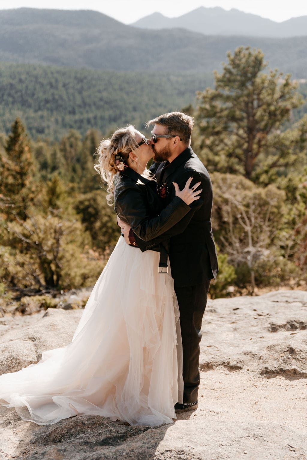 Bride and grooms first kiss at their estes park elopement in hermit park