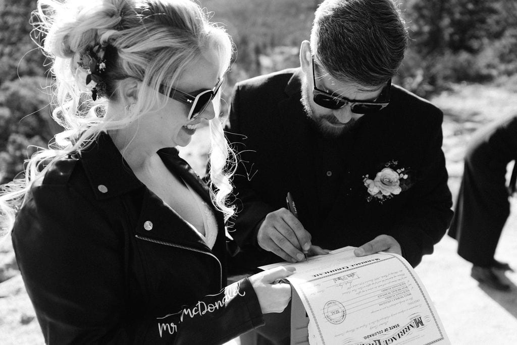 Bride and groom sign their marriage license at their hermit park elopement