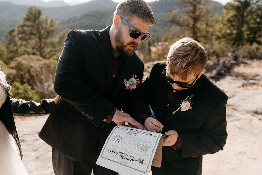 Bride and groom sign their marriage license at their hermit park elopement