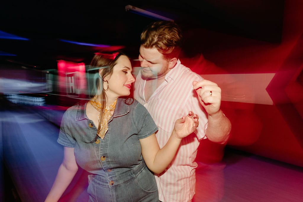 Engaged couple dancing at the bowling alley