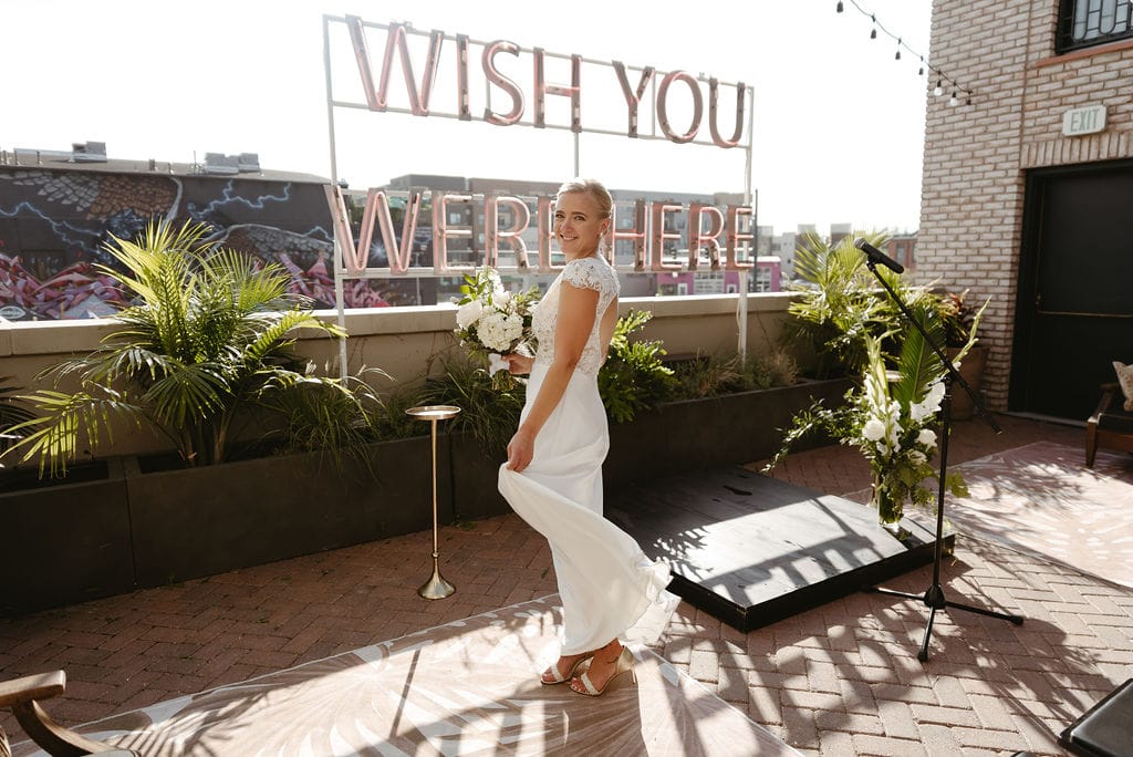 Fun Bridal Portrait at the Wish You Were Here sign at the Ramble Hotel