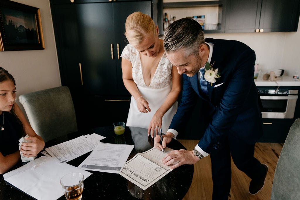 Couple Signing Marriage License at Ramble Hotel Room
