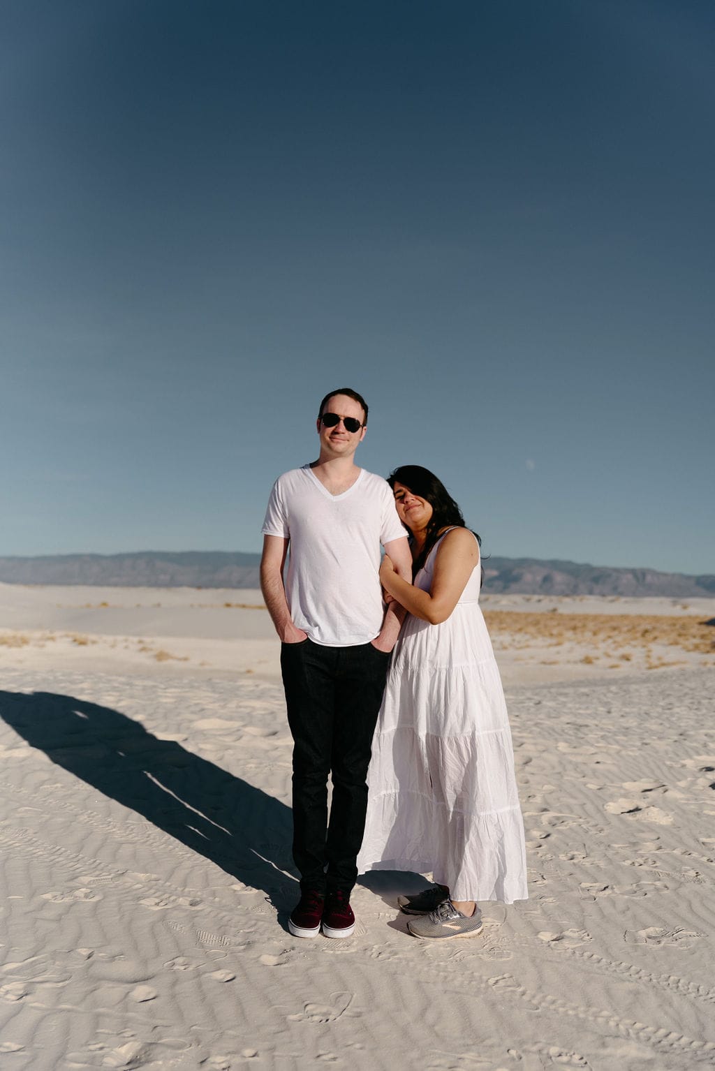 Couple in the desert with sunglasses and sand dunes