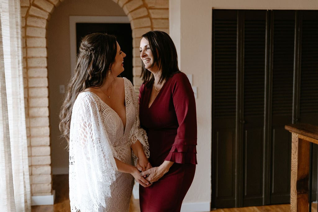 Mom helps bride get dress on