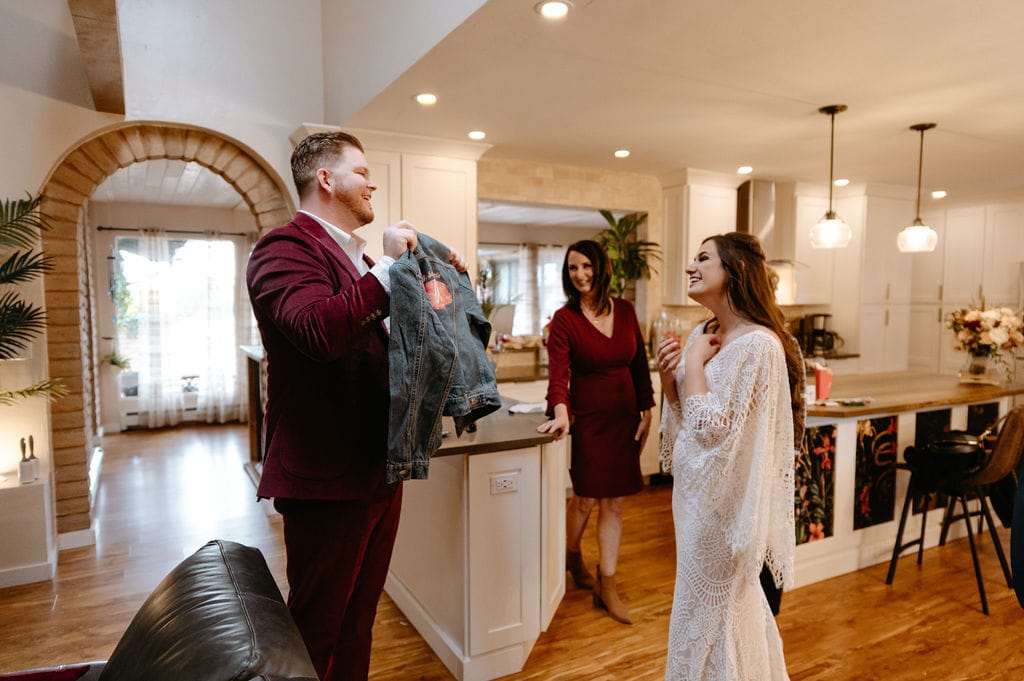Groom presents his bride with a jacket that says Wifey on it.
