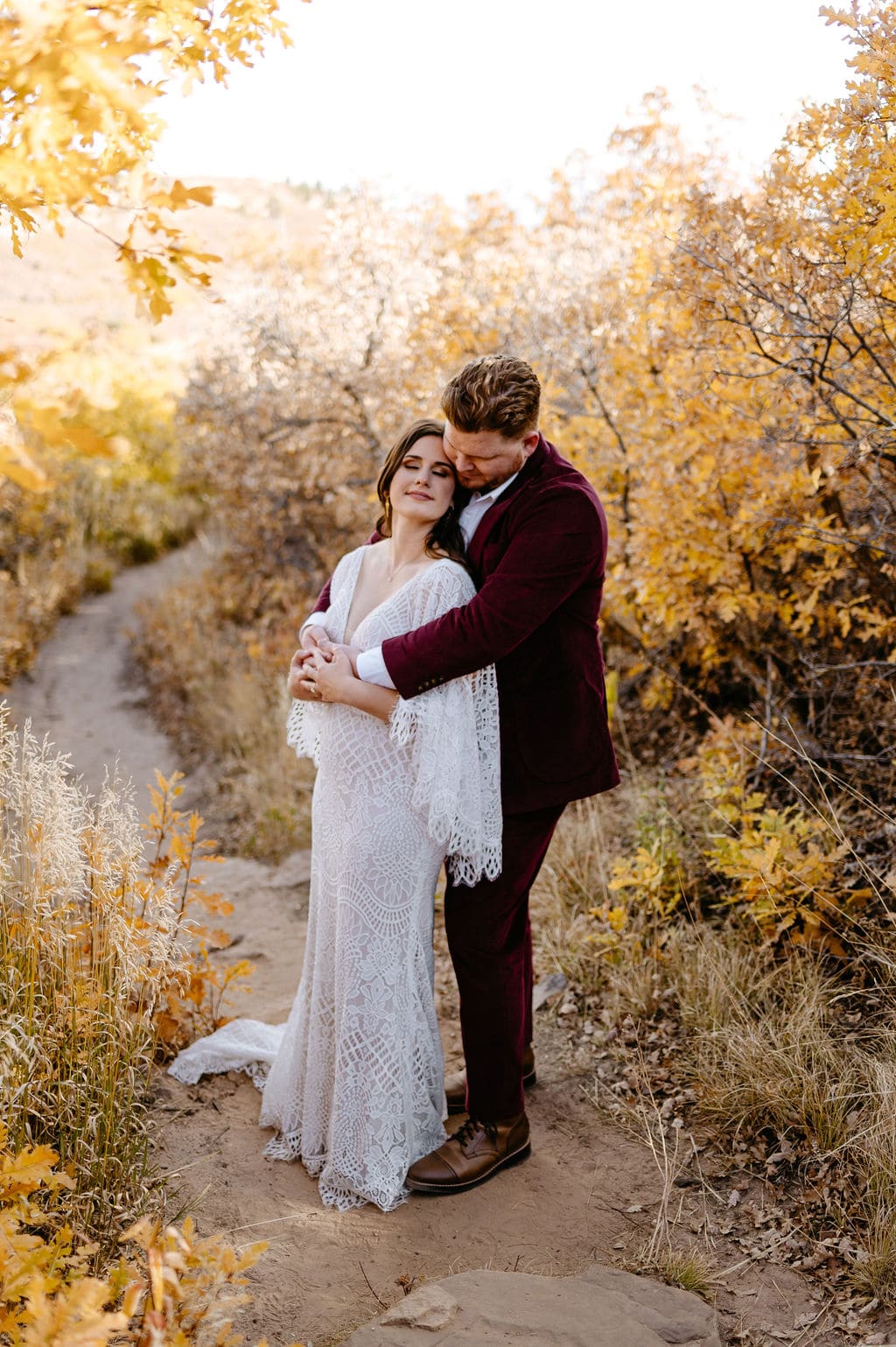 Wedding Couple Surrounded by fall colors at their colorado elopement at Roxborough State Park in October
