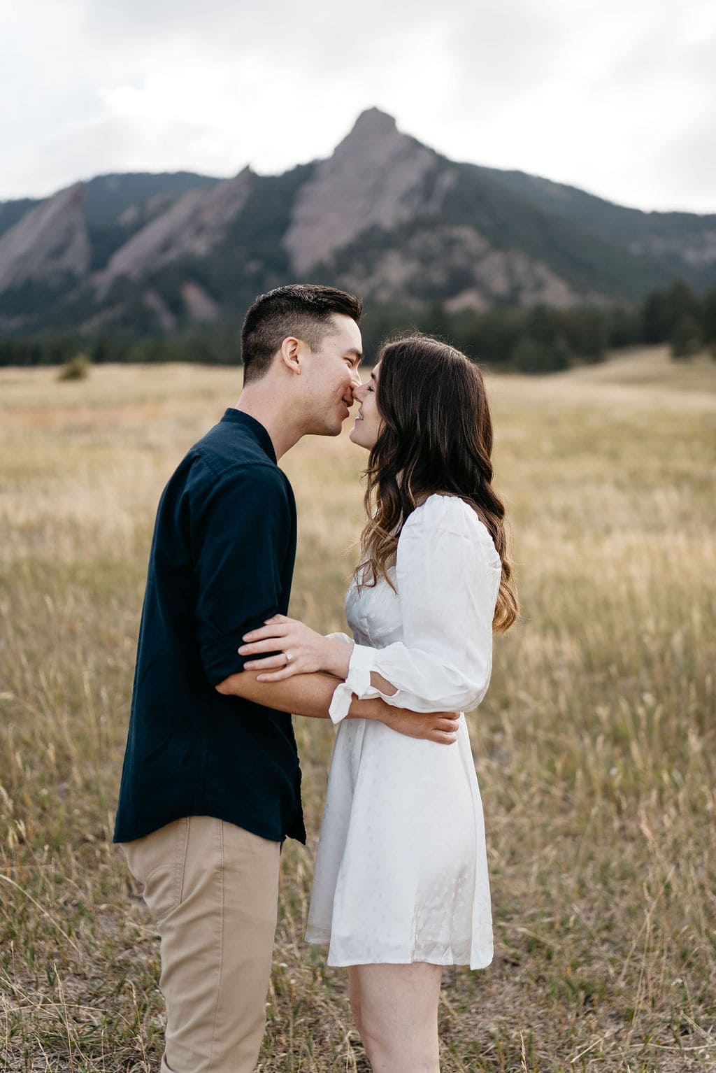 Kissing in front of the flatirons in boulder colorado 