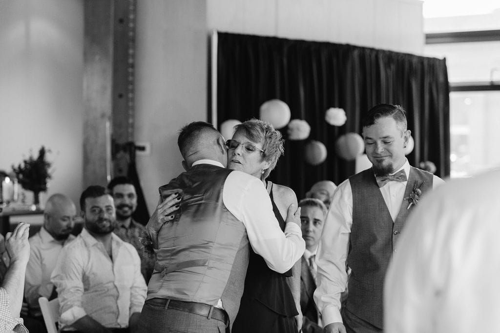 Groom hugs his mom at his wedding