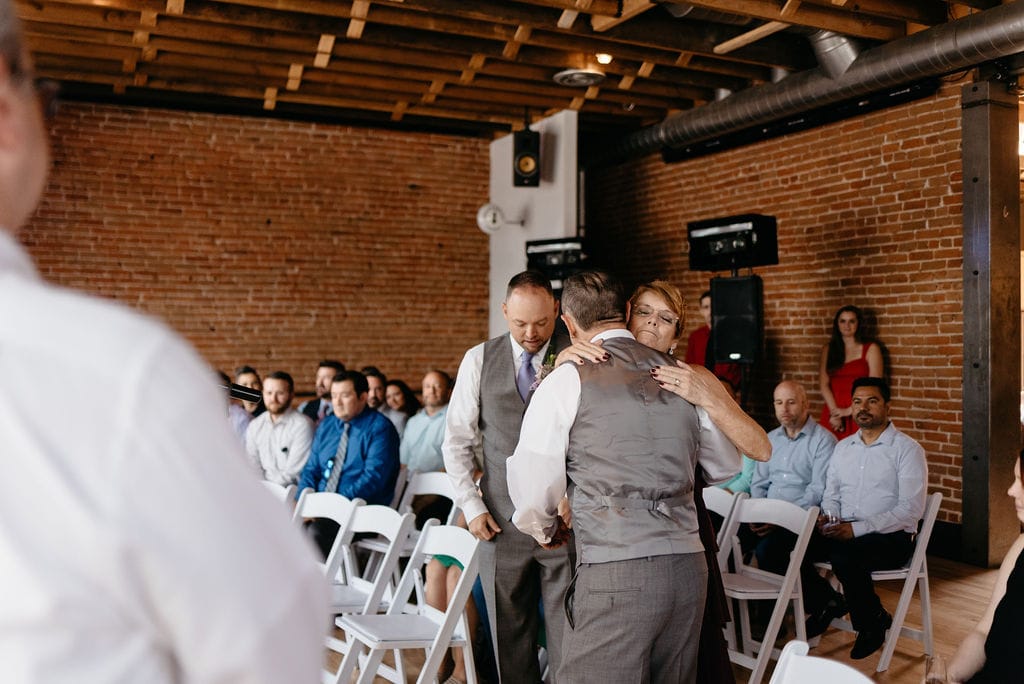 Groom hugs his mom at his wedding