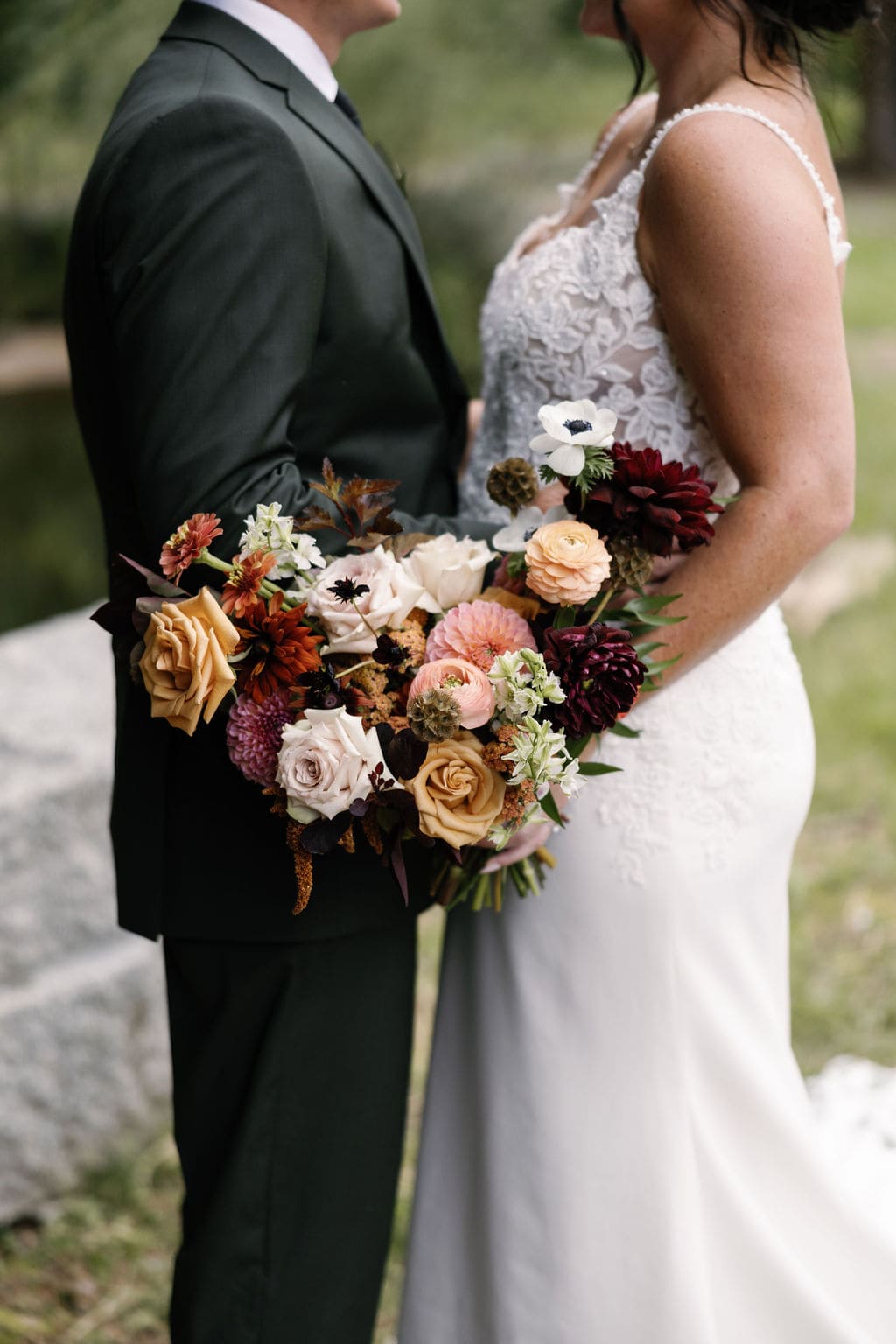 Bride and groom and bridal bouquet at Blackstone Rivers Ranch in Idaho Springs Colorado during their rainy wedding