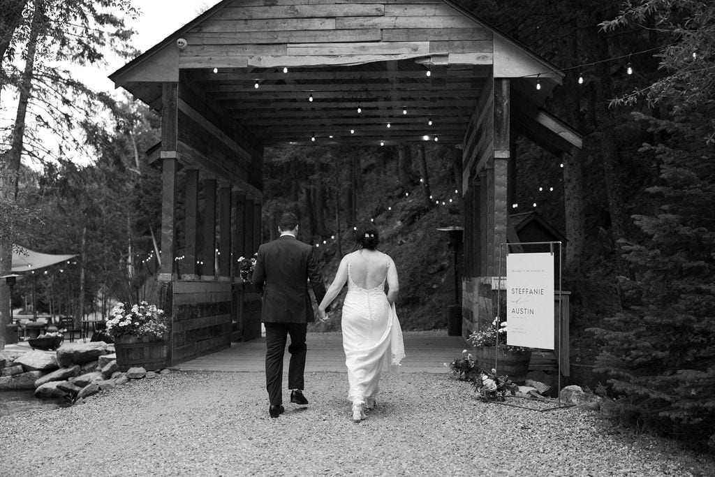 Couple walks back to their wedding reception at blackstone rivers ranch in idaho springs