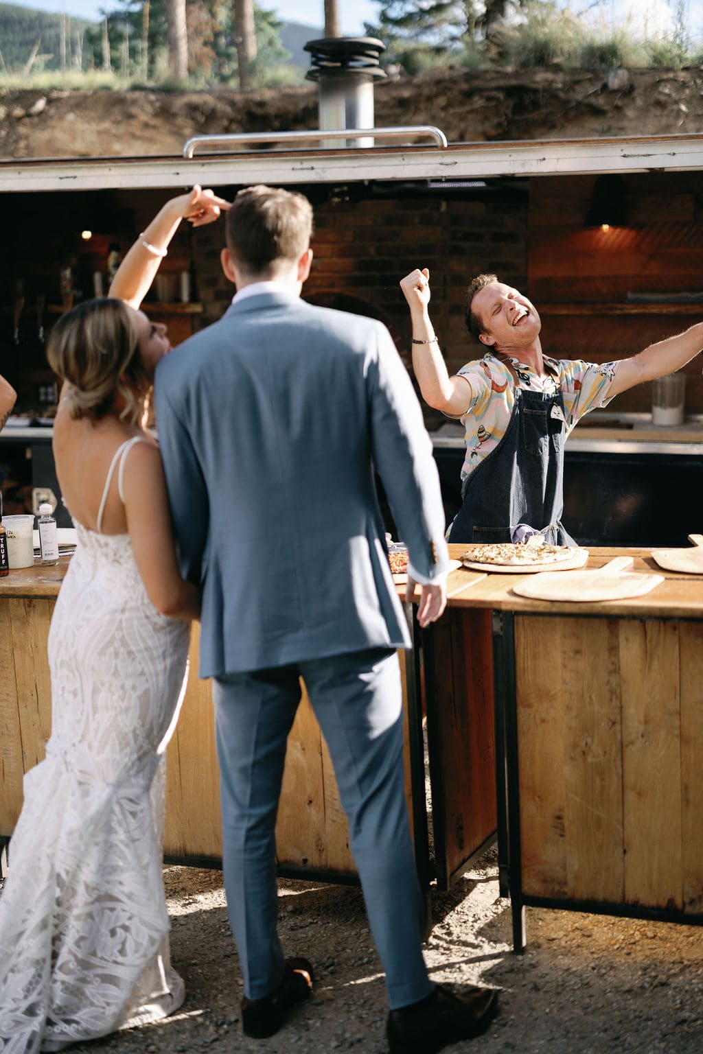 Ryan with Mountain Crust Catering Dances as he serves pizza to the happy couple