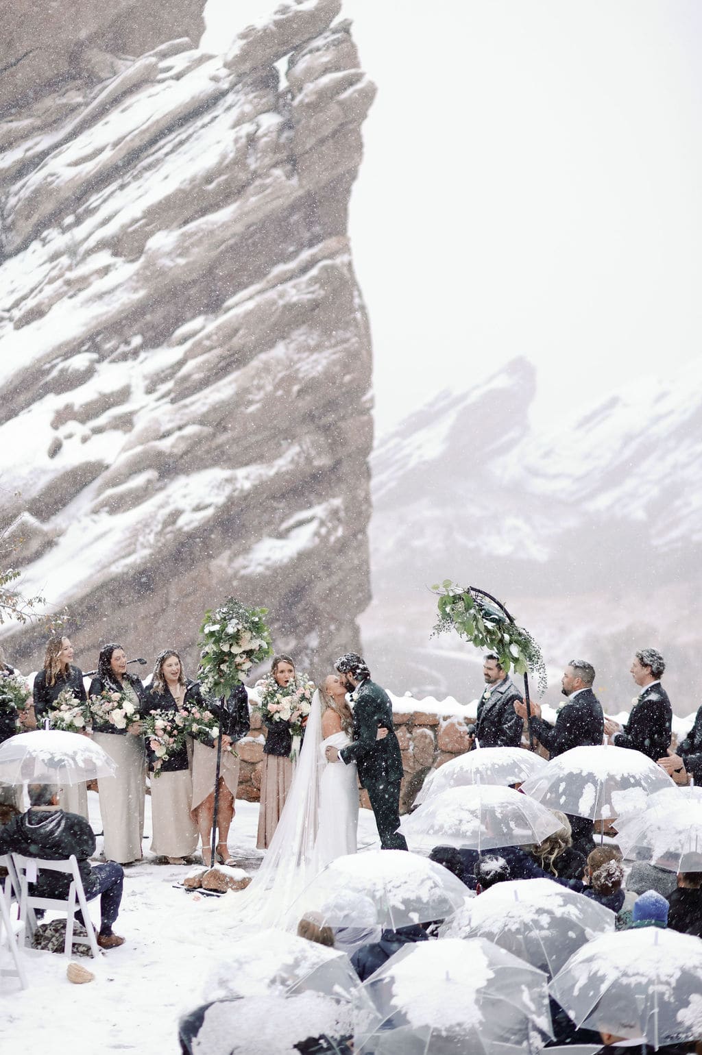 Gorgeous first kiss photo in the snow at red rocks wedding ceremony