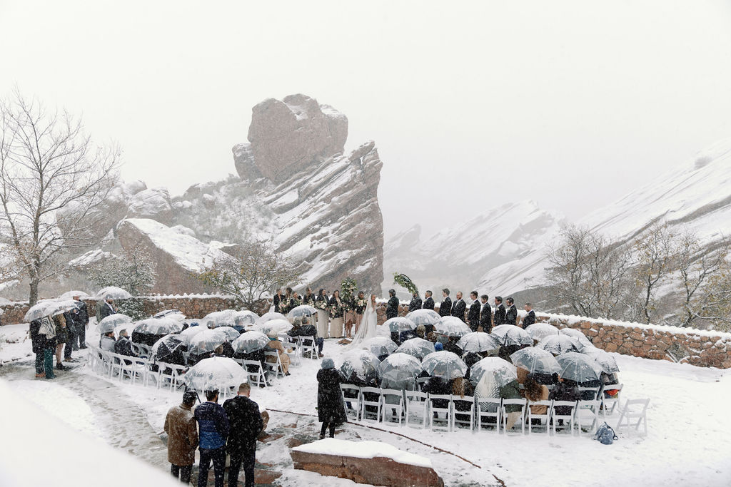 Romantic winter wedding ceremony at Red Rocks in snowstorm