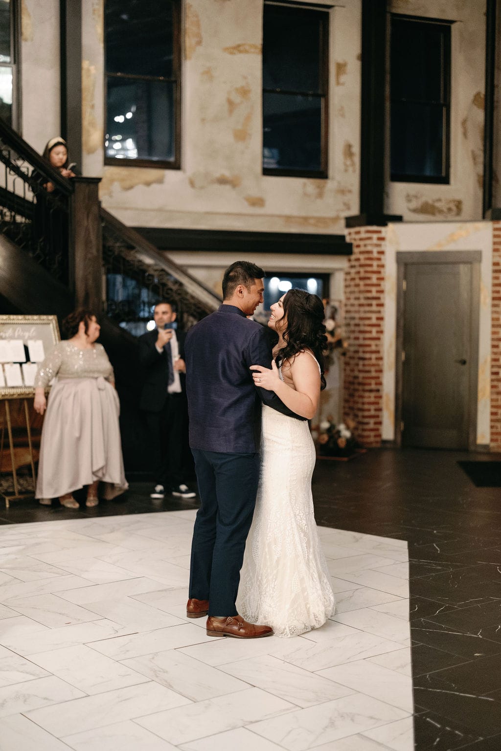 Couple smiles at each other during their first dance as husband and wife at Ironworks Wedding Venue at their reception party