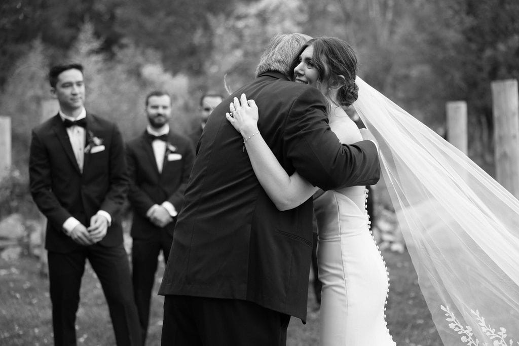 Bride hugs her dad as he gives her away for wedding ceremony at her buena vista wedding