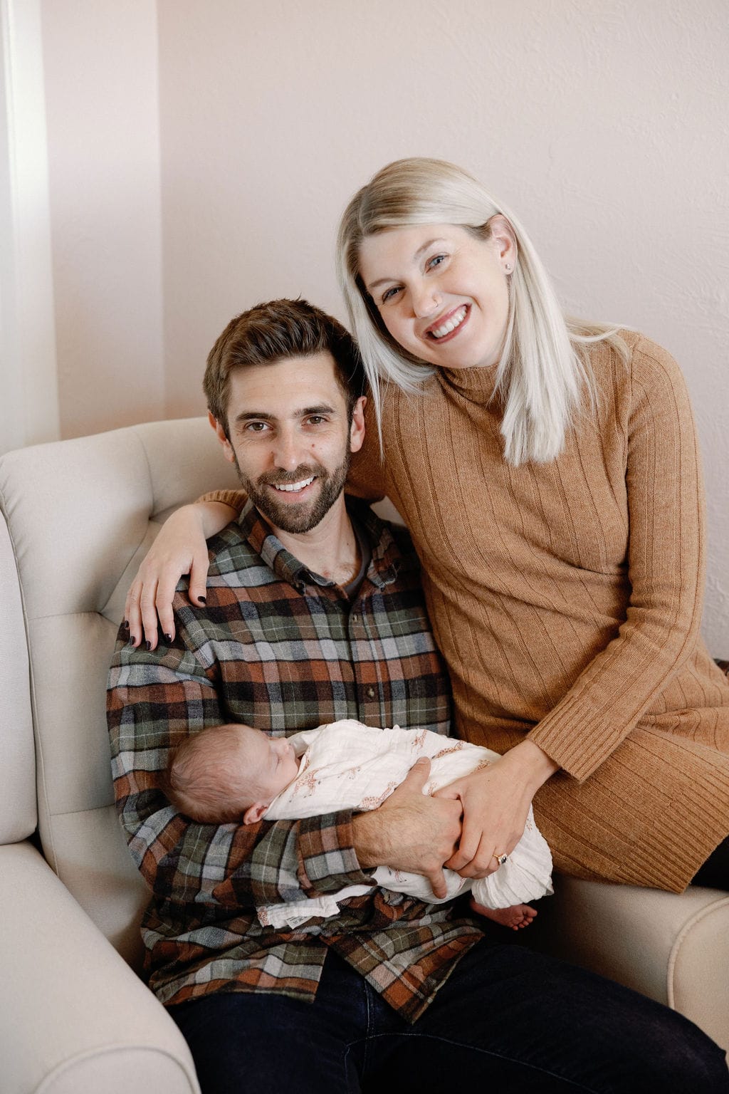 Couple holds baby in the nursery during her in home newborn session