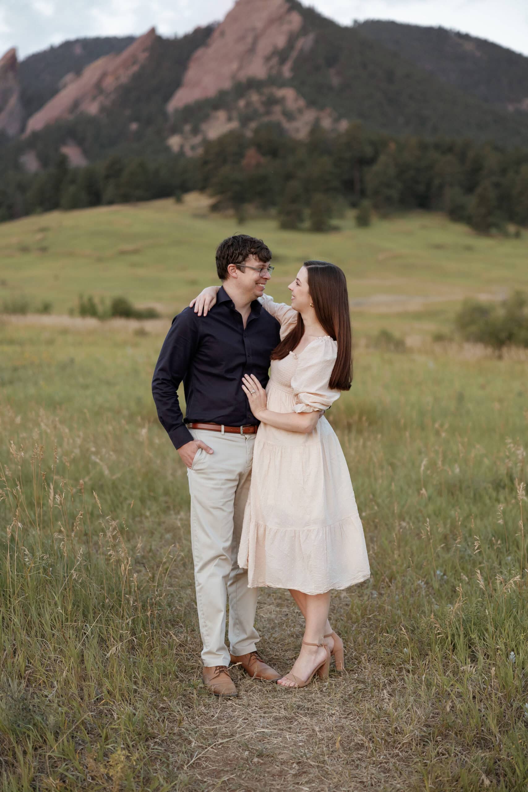 Couples portrait in front of the flatirons at sunrise in chautauqua park