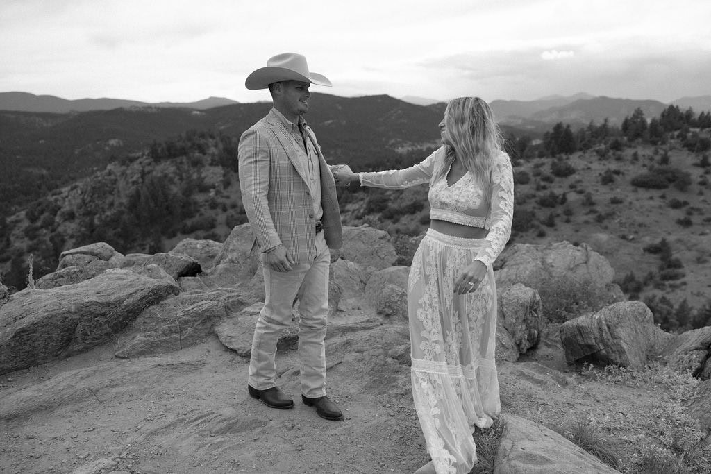 Couple explores a rocky overlook at their mountain country chic engagement session at mount falcon west