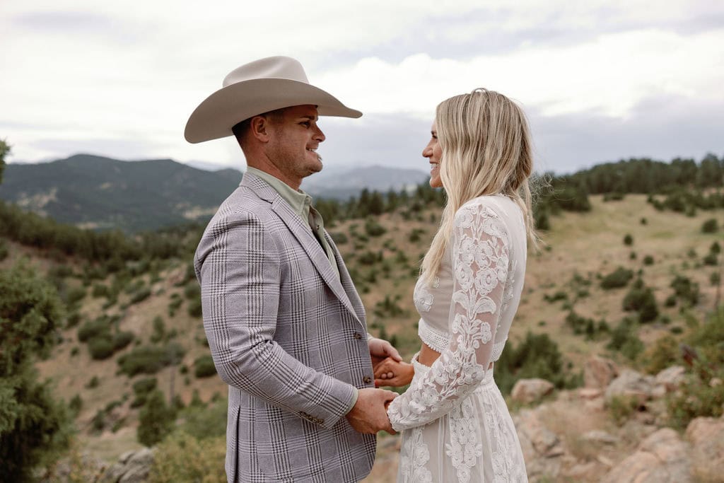 Couple looks at each other at the overlook at mount falcon west park with the mountains in the background