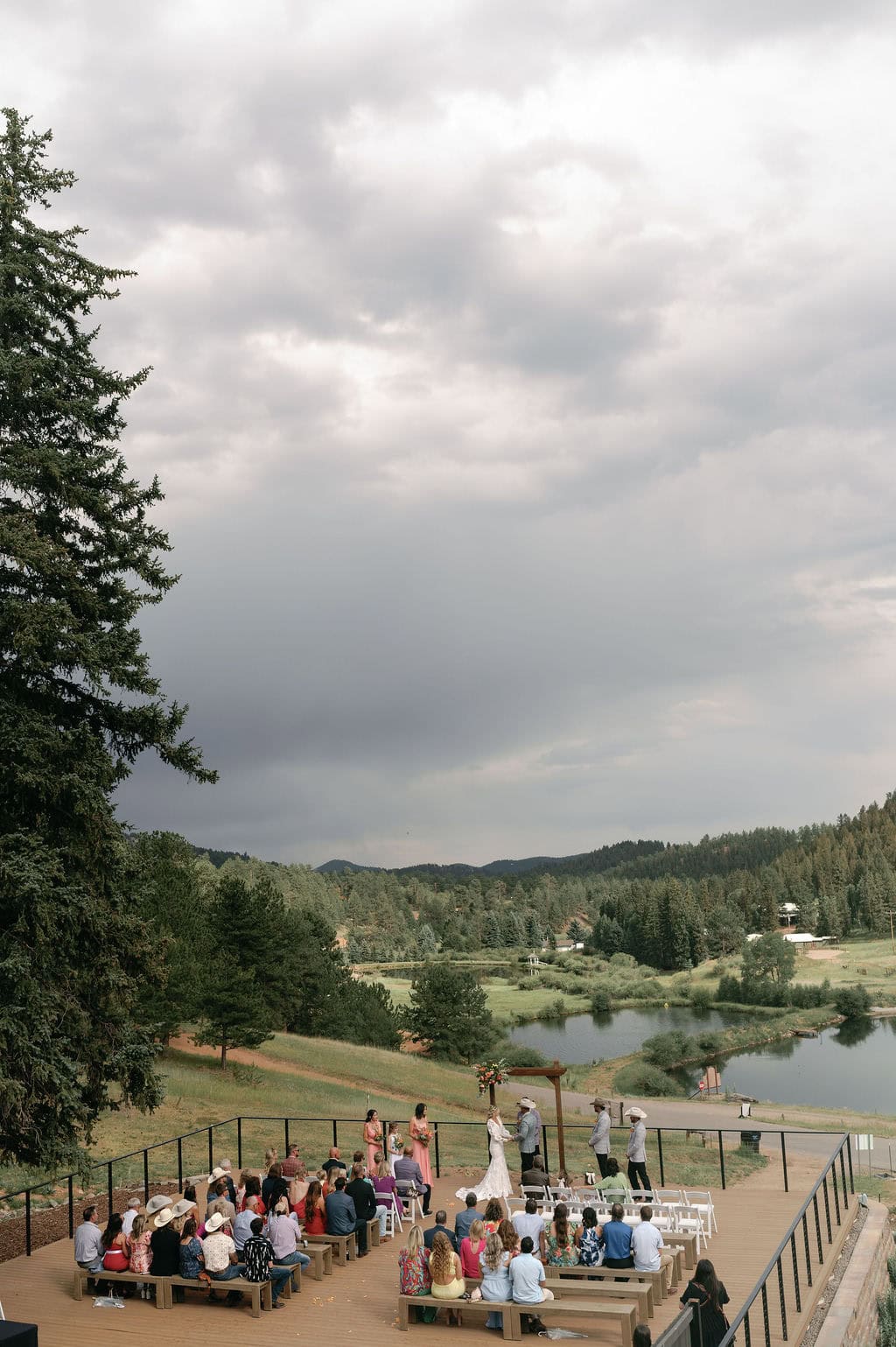 dreamy lakeside wedding ceremony at Mountain view ranch lakeview in pine colorado, with country chic vibes on a cloudy day.
