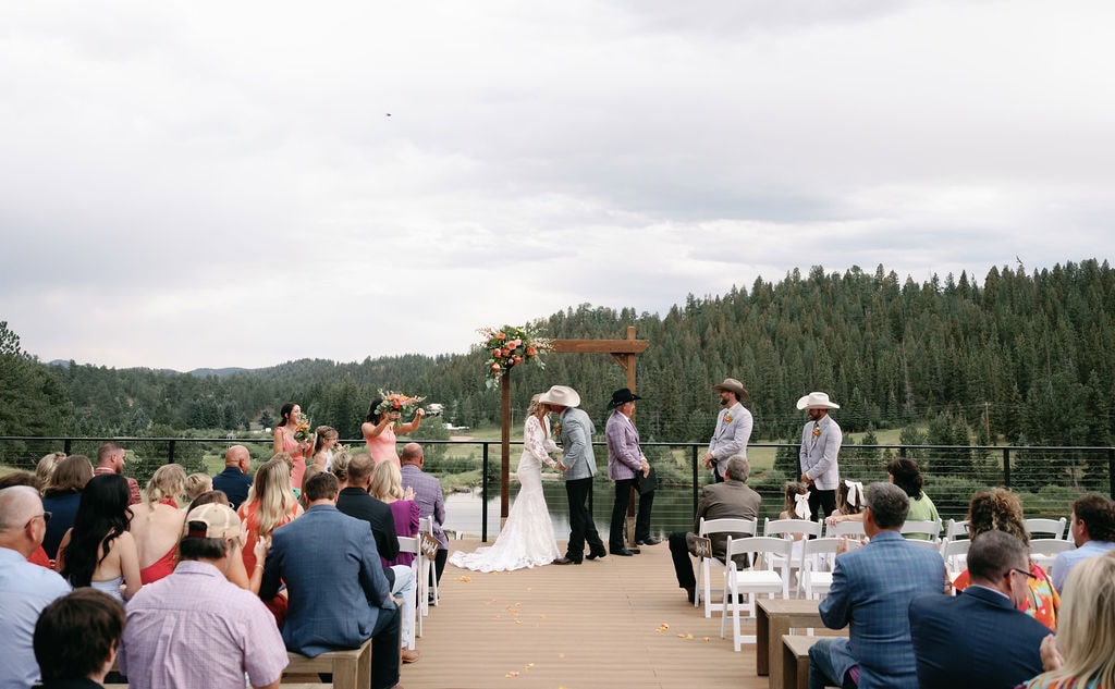 dreamy lakeside wedding ceremony at Mountain view ranch lakeview in pine colorado, with country chic vibes on a cloudy day.