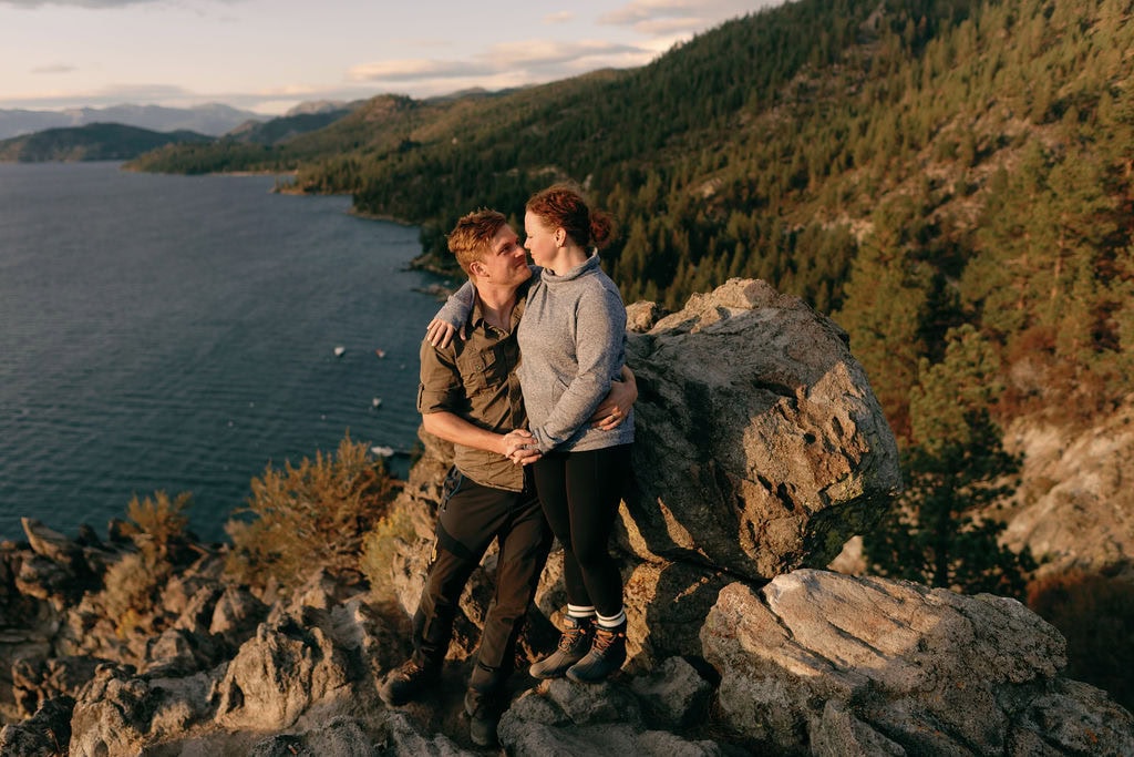 South Lake Tahoe Engagement Photos at Cave Rock at sunset in the fall. Couple looks out over the lake
