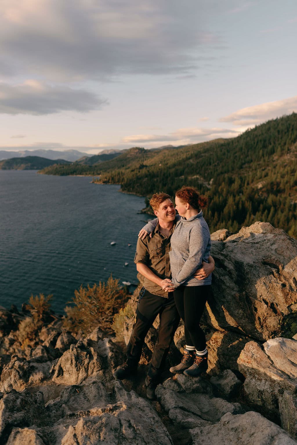 South Lake Tahoe Engagement Photos at Cave Rock at sunset in the fall. Couple looks out over the lake