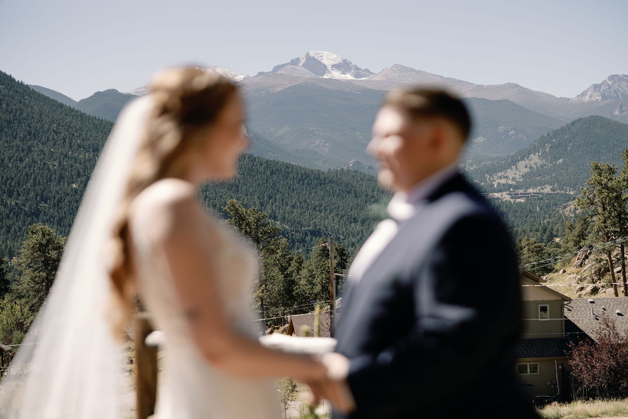 Longs peak in the background during brides' first look