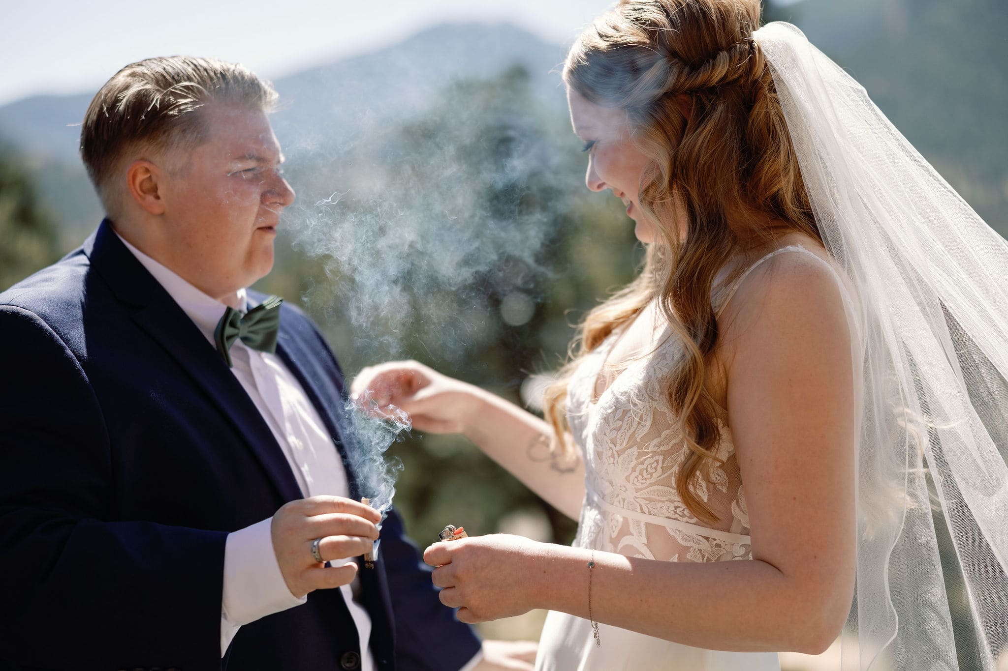 lgbtq couple shares a joint before they get married in estes park colorado during their cannabis friendly colorado wedding