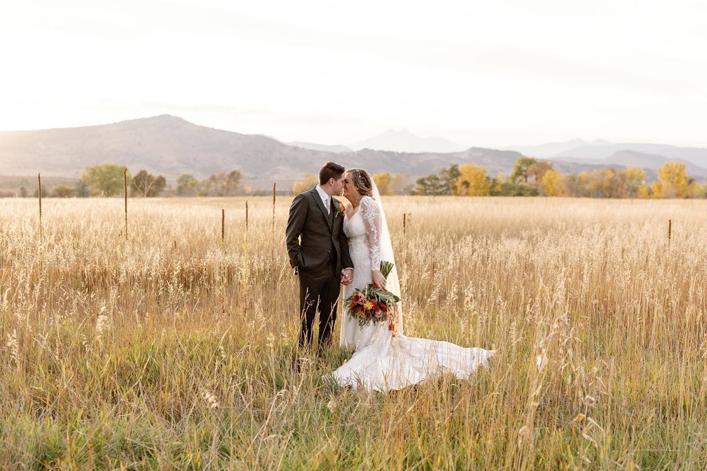 Bride and Groom Portraits at their Shupe Homestead Wedding near boulder colorado outside in a field at sunset