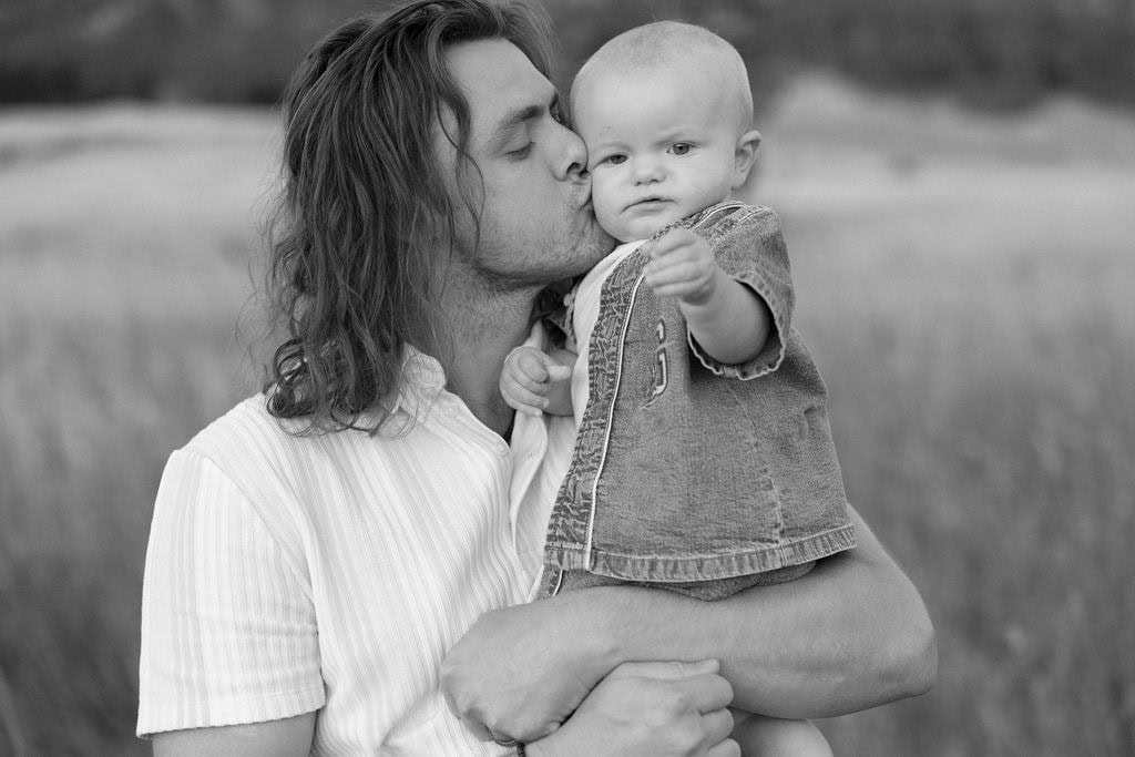 sweet photo of dad kissing his baby at his sunrise chautauqua portrait session