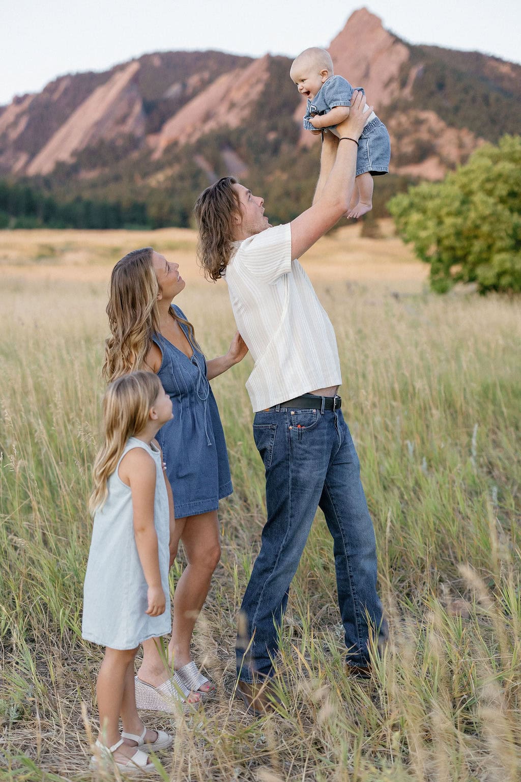 Sweet portrait of family at chautauqua park in boulder. Dad lifts their baby inot the air
