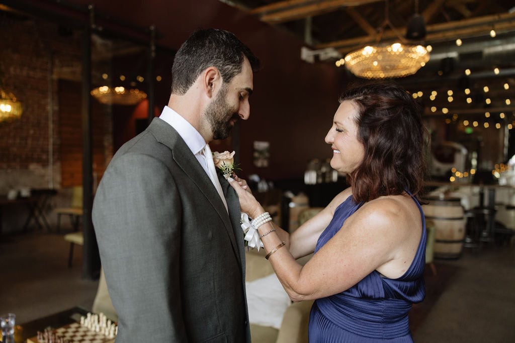 Groom gets his bout pinned on by his mom at bigsby's folly just before the start of the ceremony