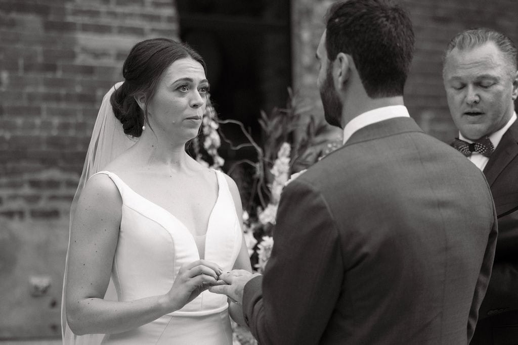Bride puts ring on grooms finger at bigsbys folly wedding