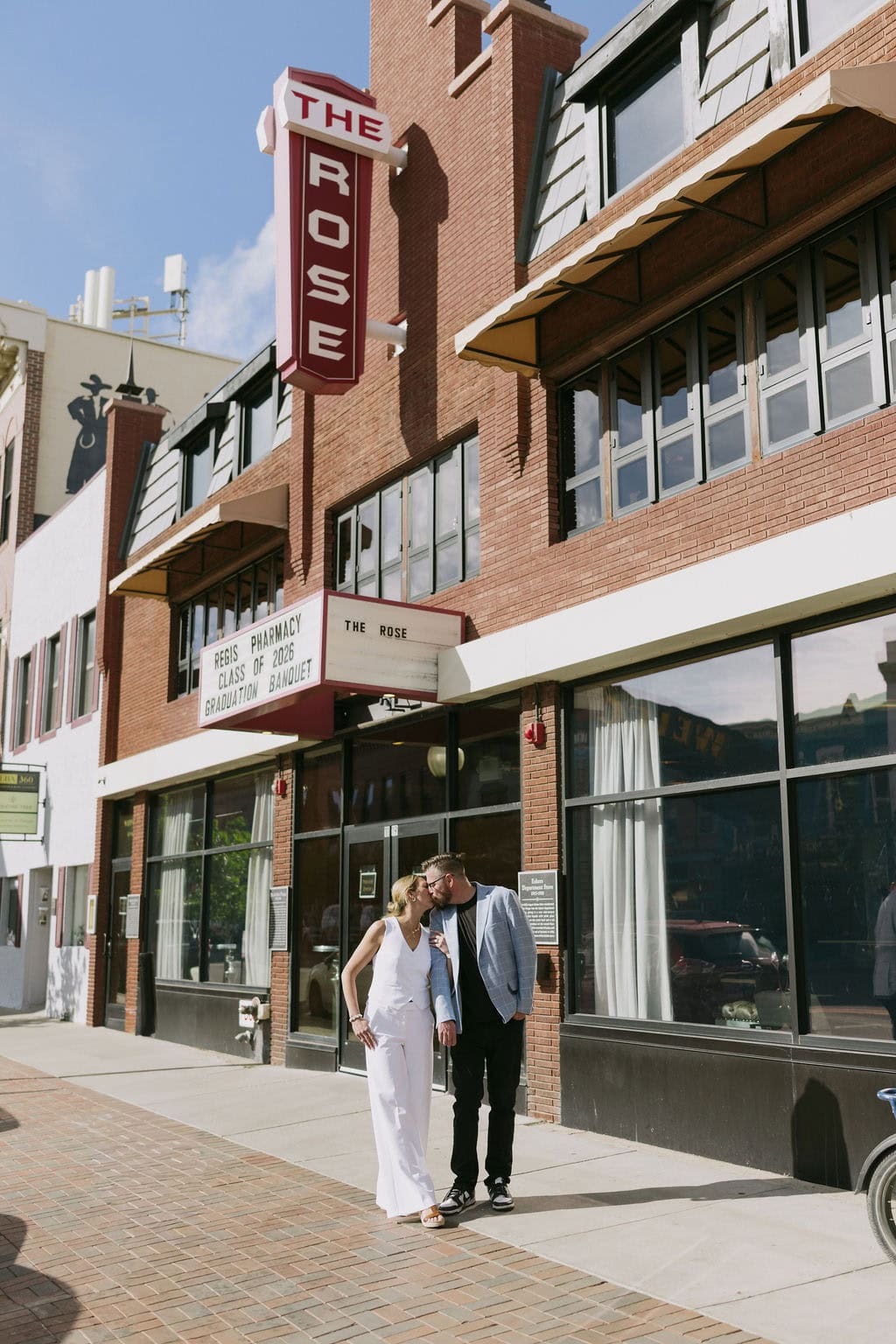 Bride and groom sharing a cute moment on the sidewalk before their welcome party at The Rose