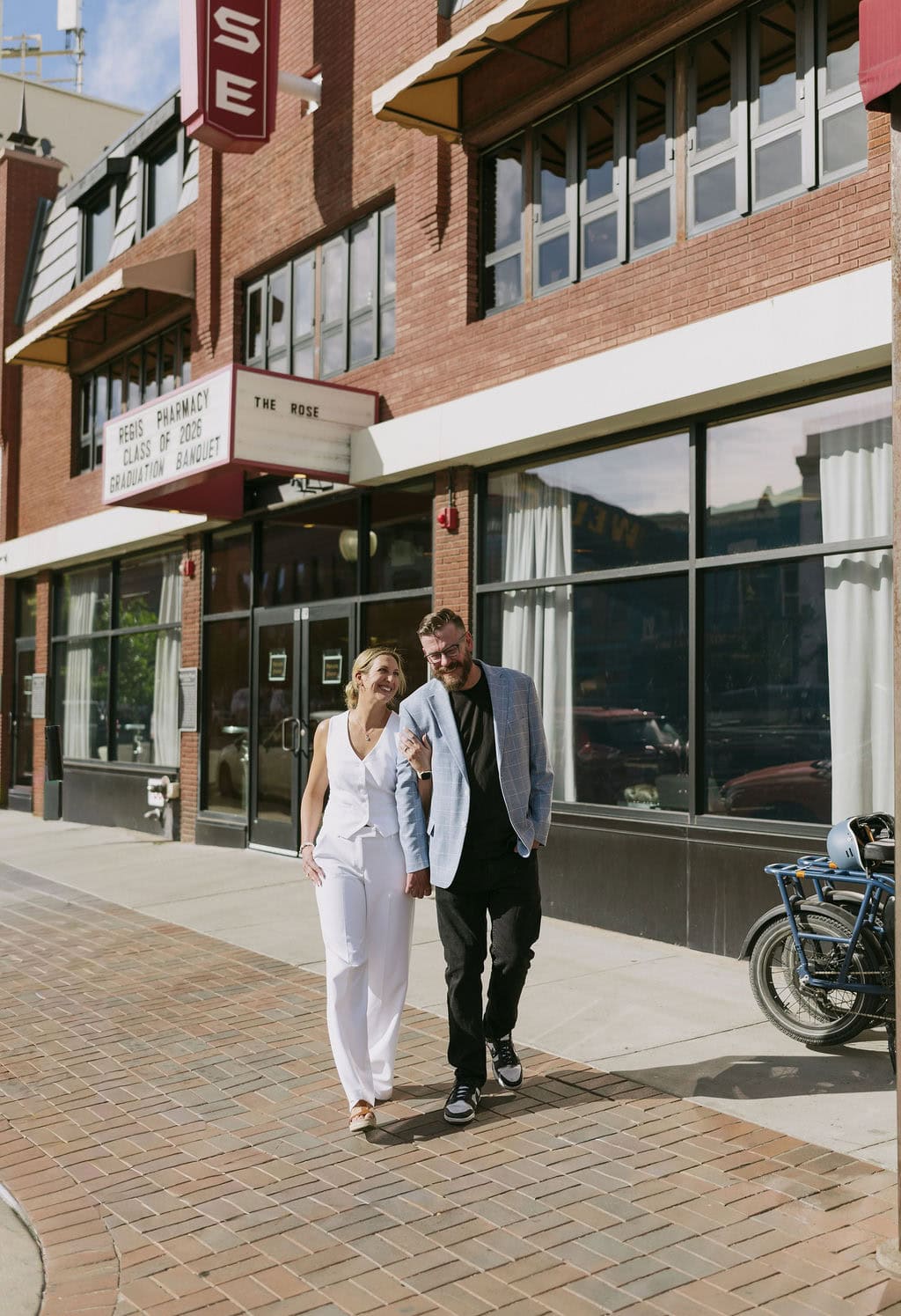 Bride and groom sharing a cute moment on the sidewalk before their welcome party at The Rose