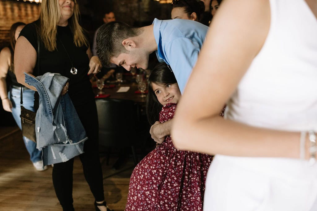 Emotional hugs and laughter captured during a Colorado wedding welcome party at The Rose