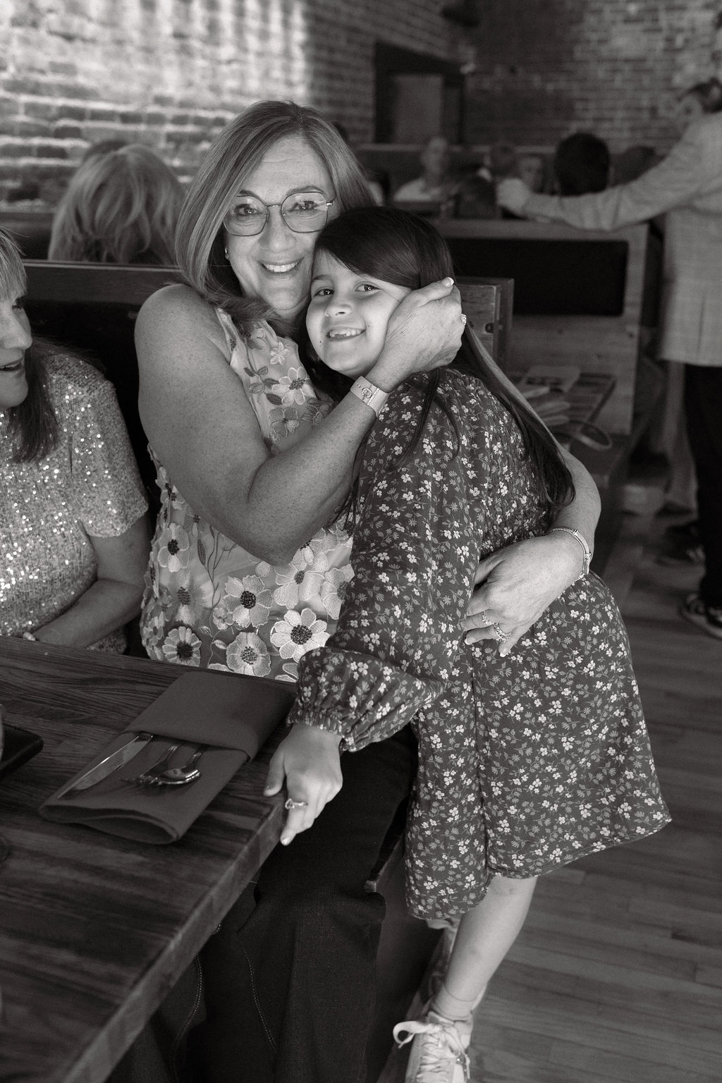 Emotional hugs and laughter captured during a Colorado wedding welcome party at The Rose