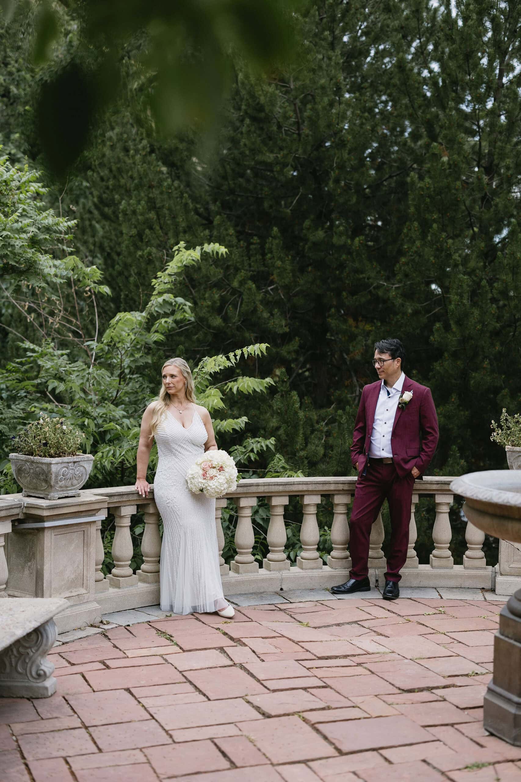 Bride and groom stand on the stone patio in the gardens at grant humphrey's mansion wedding 