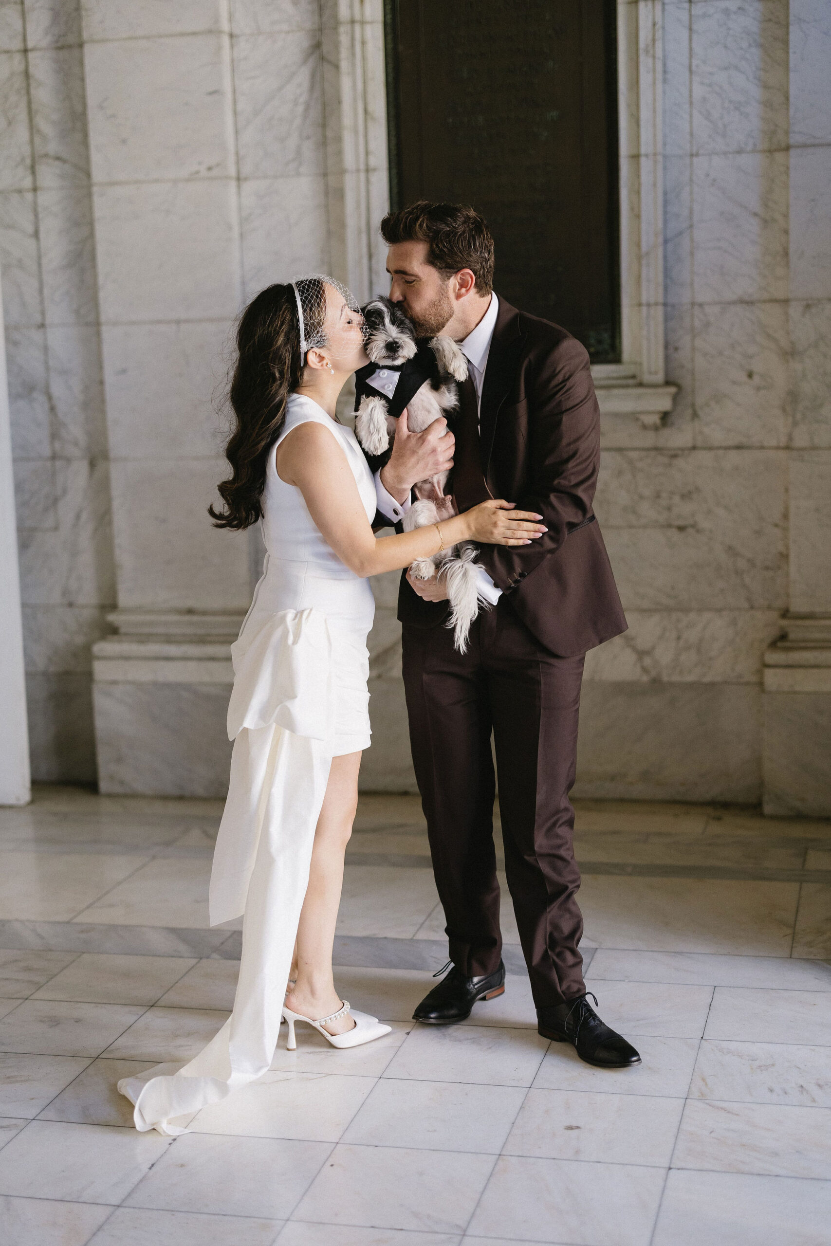 Couple loves on their dog outside of their courthouse wedding in Little Rock