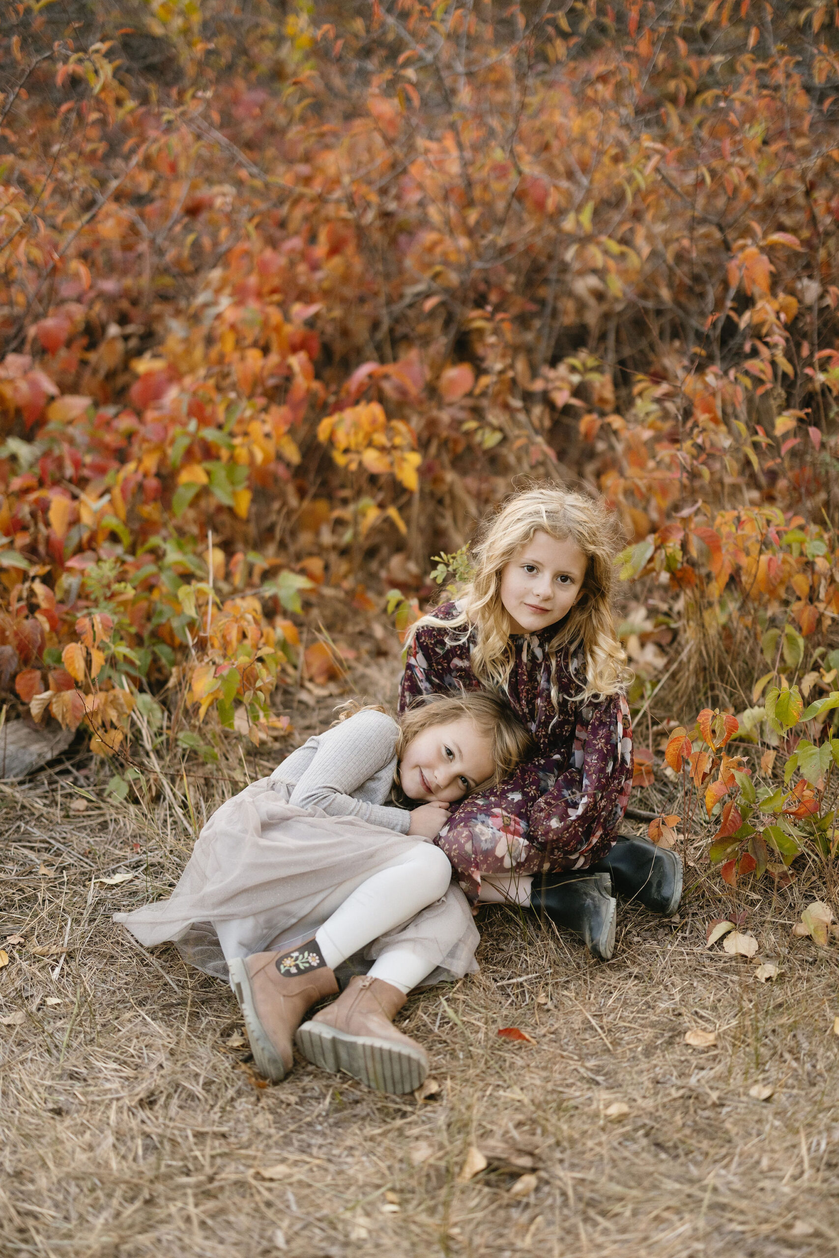 two sisters sit together in fall colors at south mesa trailhead